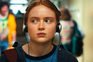 A close up of Max Mayfield as she walks through the school hallway with headphones on