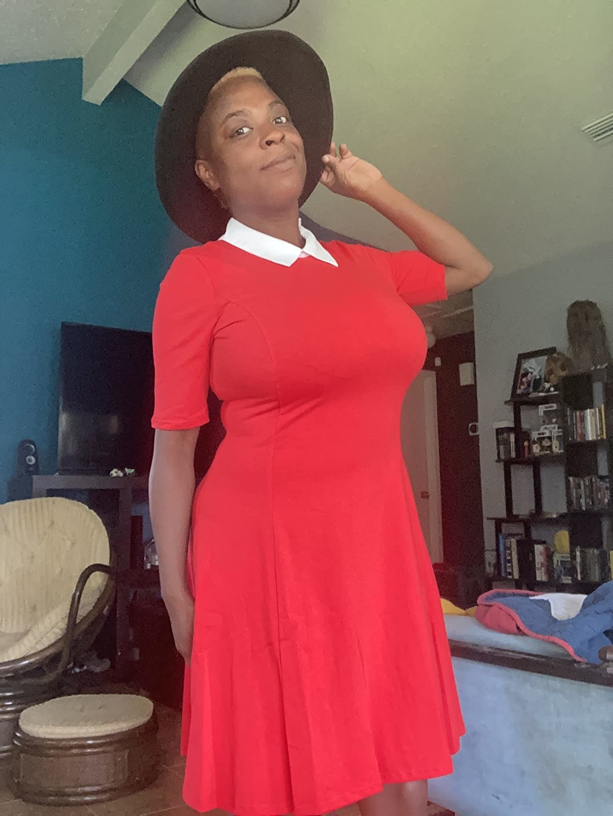Reviewer wearing red short sleeve mini dress with white collar and black brimmed hat