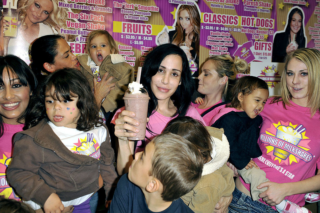 Nadya holding a milkshake amongst children