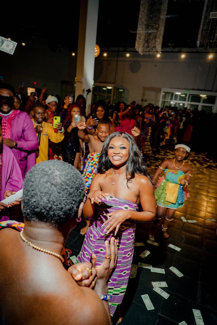 A man and woman in festive clothing dance and smile at the camera