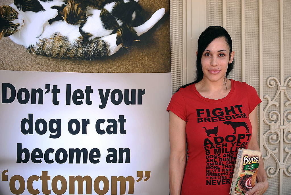 Nadya next to a poster that says, &quot;Don&#x27;t let your dog or cat become an &#x27;octomom&#x27;&quot;
