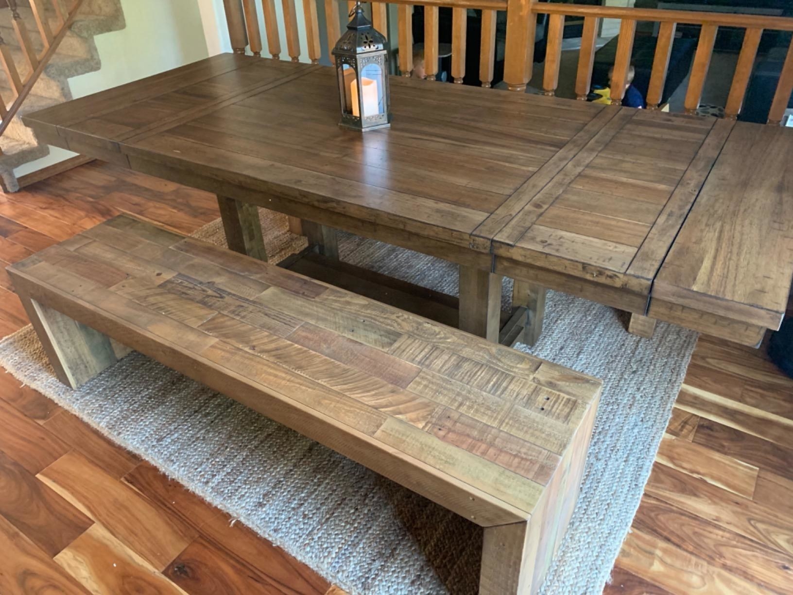 a reviewer photo of the table with a matching bench in a dining room