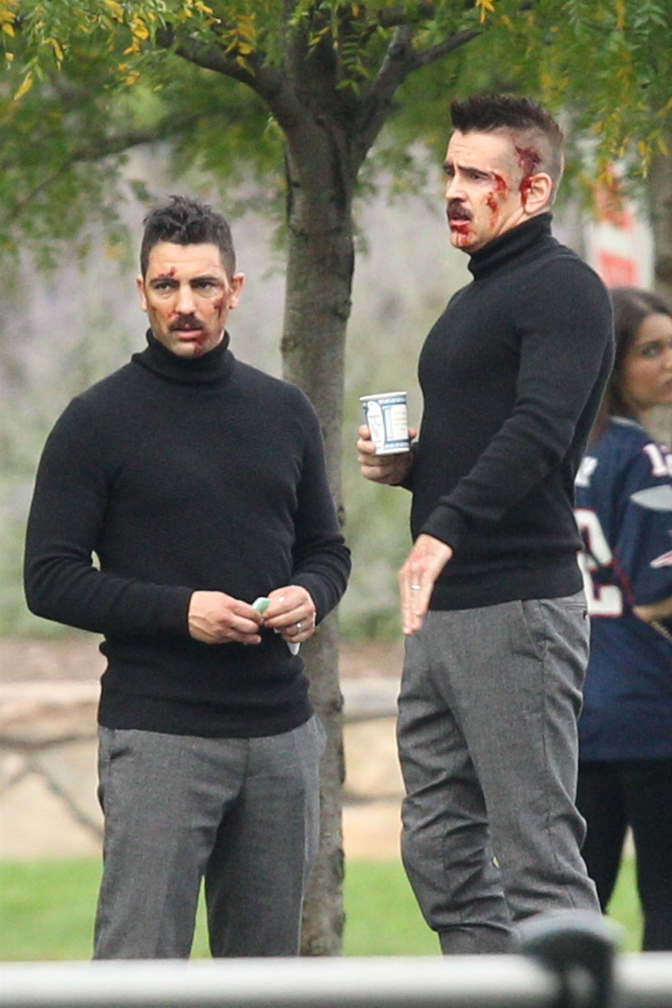 Colin and his body double with bloody marks on their faces and wearing turtlenecks