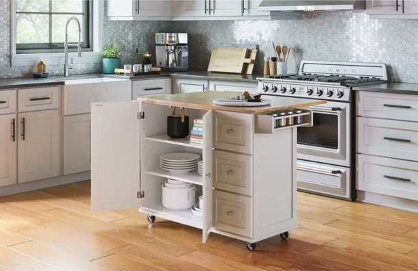 The island cart in a kitchen with the cabinet drawers open to show off the space
