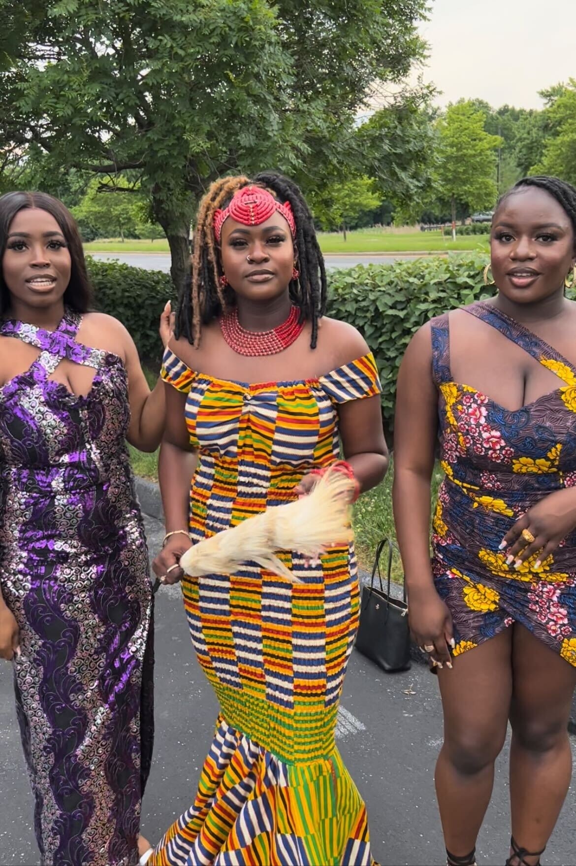 Three women in festive clothing look at the camera