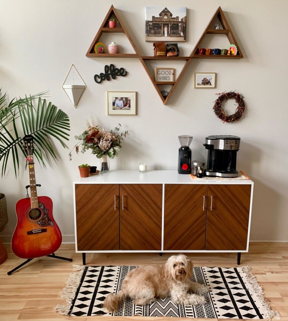 a reviewer photo of the white cabinet  with a dog in front of it