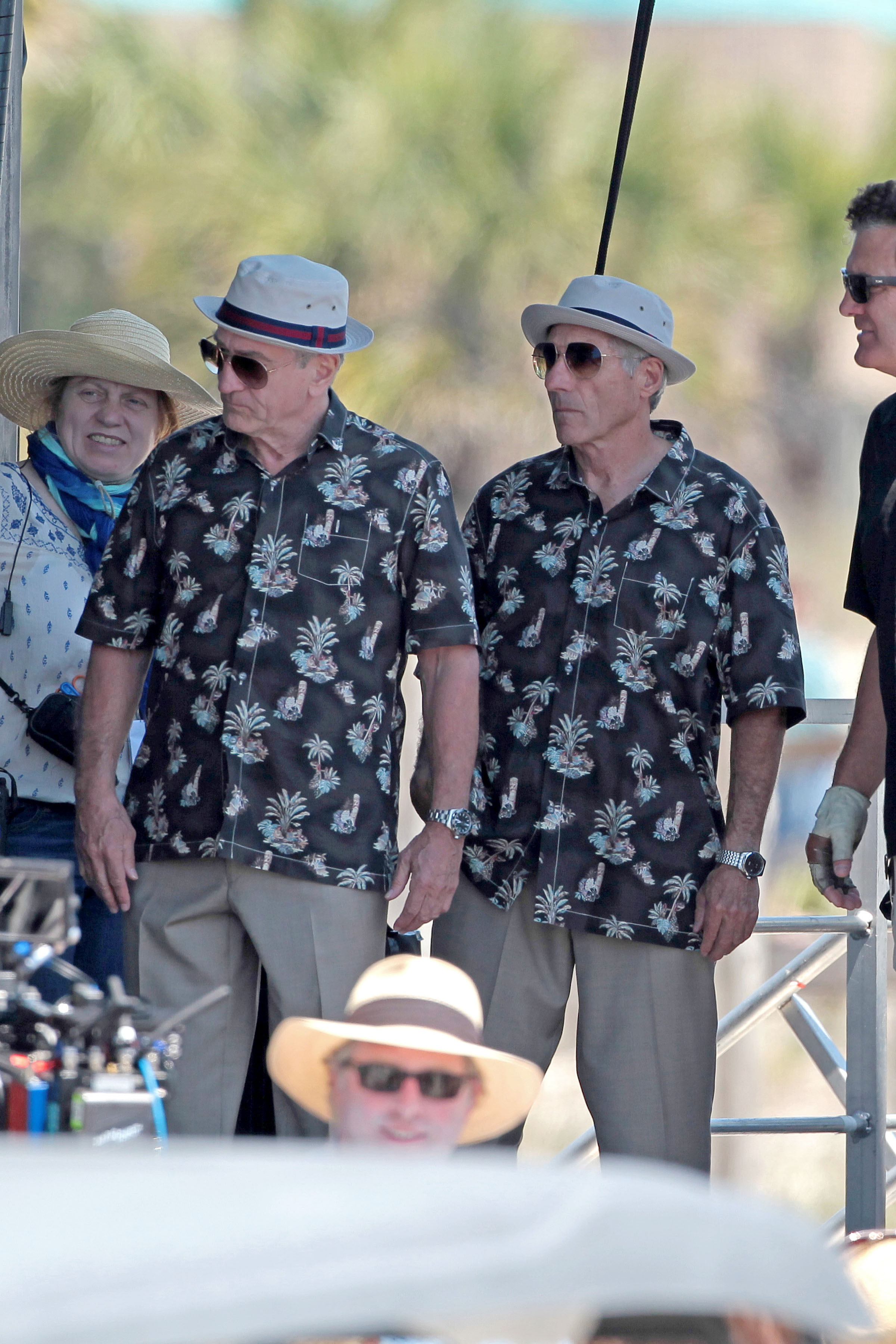De Niro and his body double wearing Hawaiian shirts, sunglasses, and brimmed hats