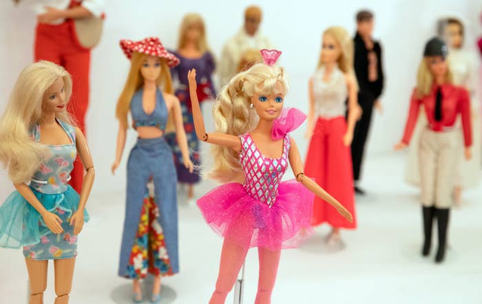Barbie dolls wearing costumes are displayed