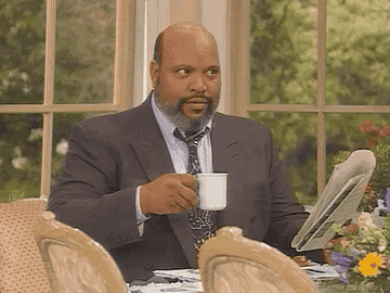 Uncle Phil from Fresh Prince of Bel Air sat holding a mug whilst raising his eyebrows