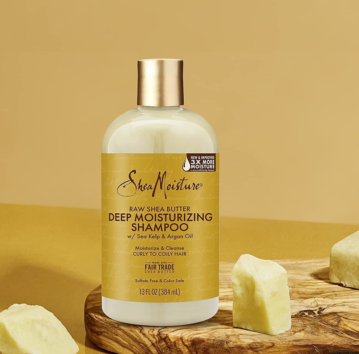 The bottle on a wooden platter surrounded by hunks of shea butter