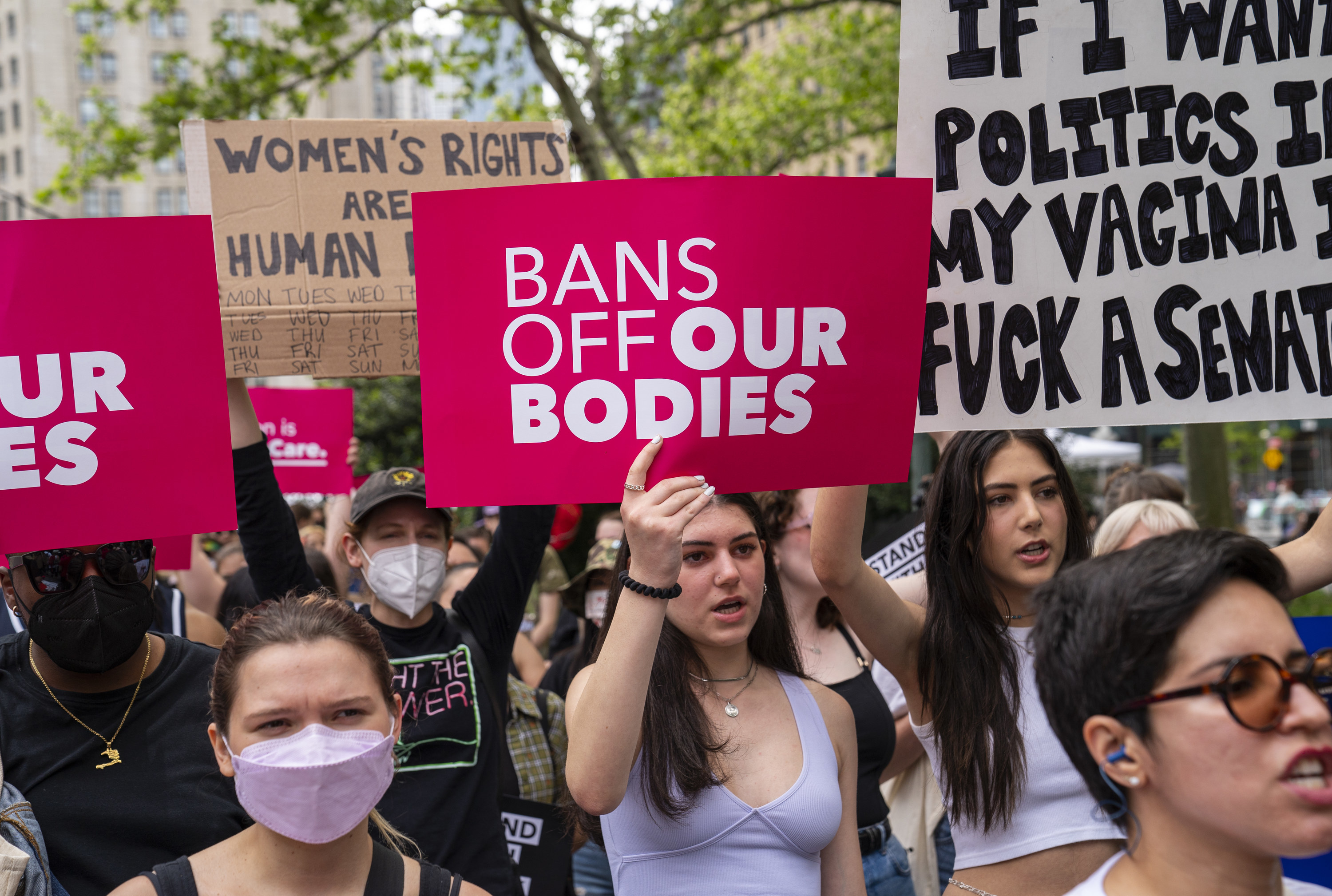 Protesters holding a bans off our bodies sign