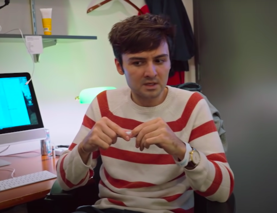 john sitting at a desk during a skit