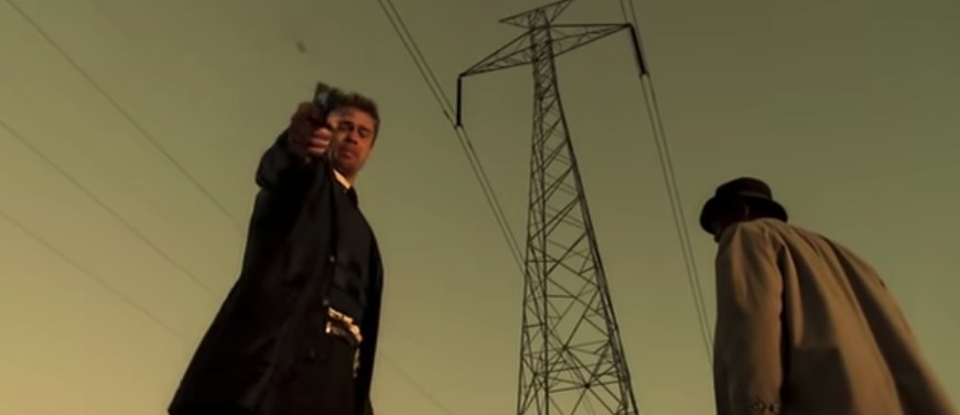 Brad Pitt firing a gun whilst Morgan Freeman looks away in Se7en