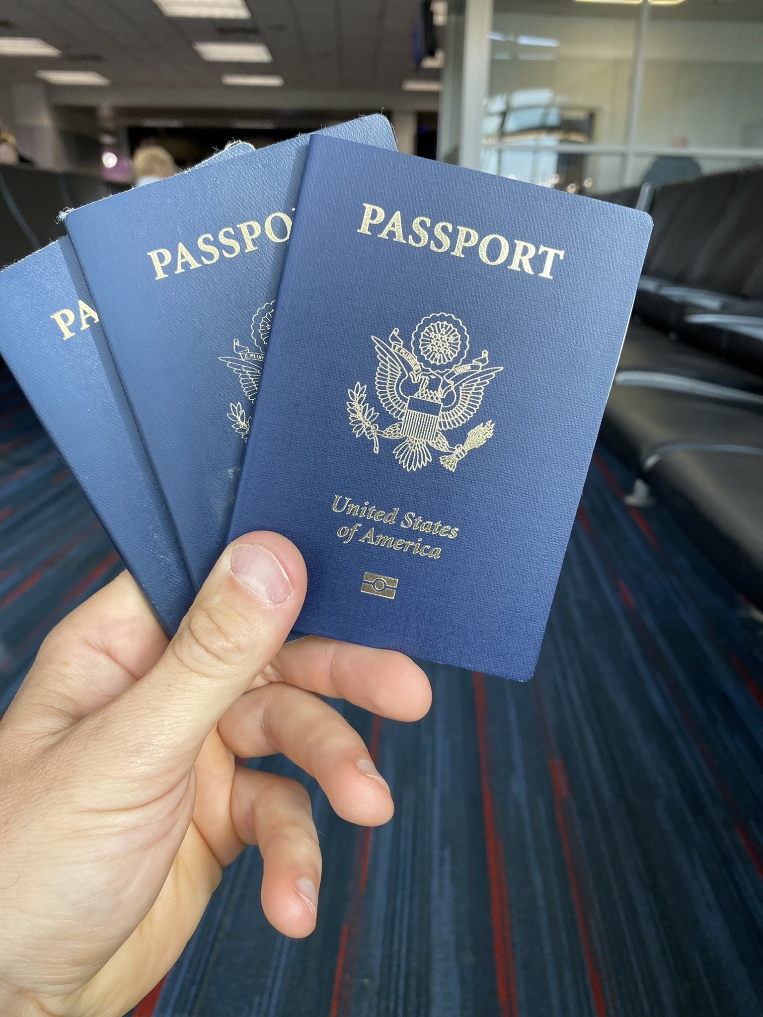 Hand holding three US passports