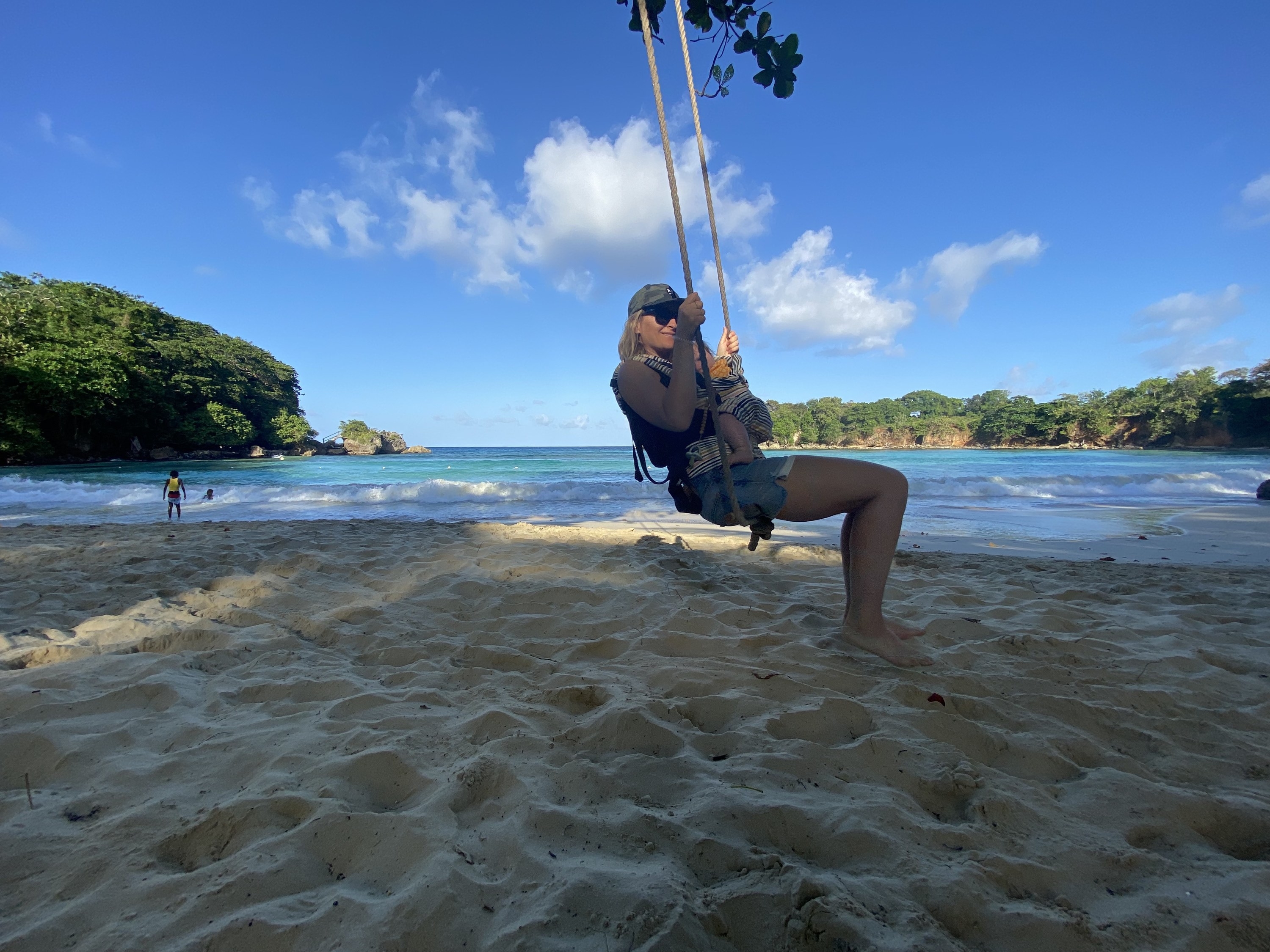 Woman on a swing in front of the ocean