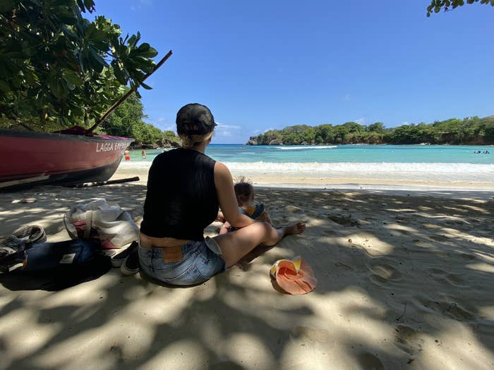 Woman sits on beach with baby