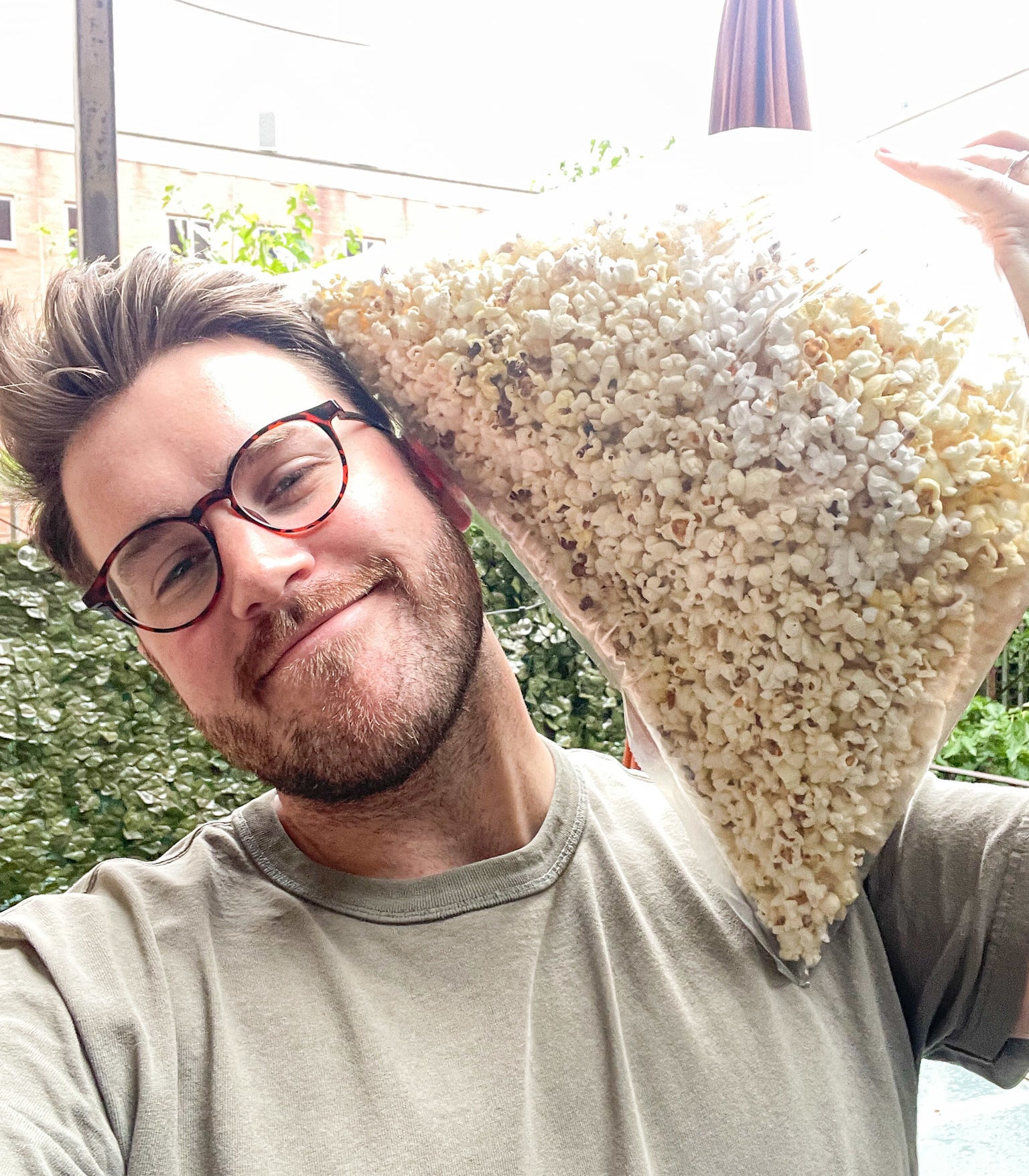 the author holding a large bag of popcorn