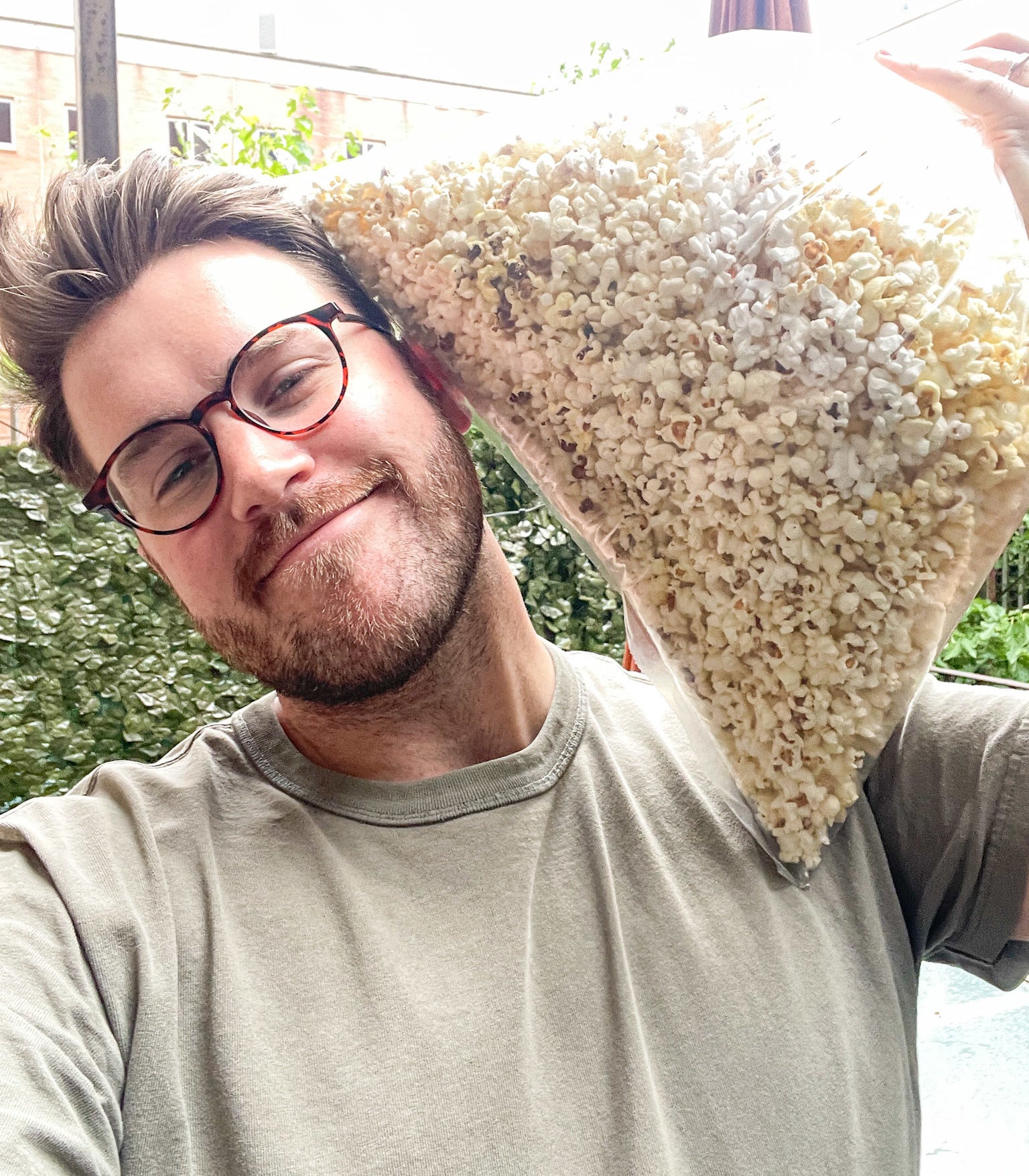 the author holding a large bag of popcorn