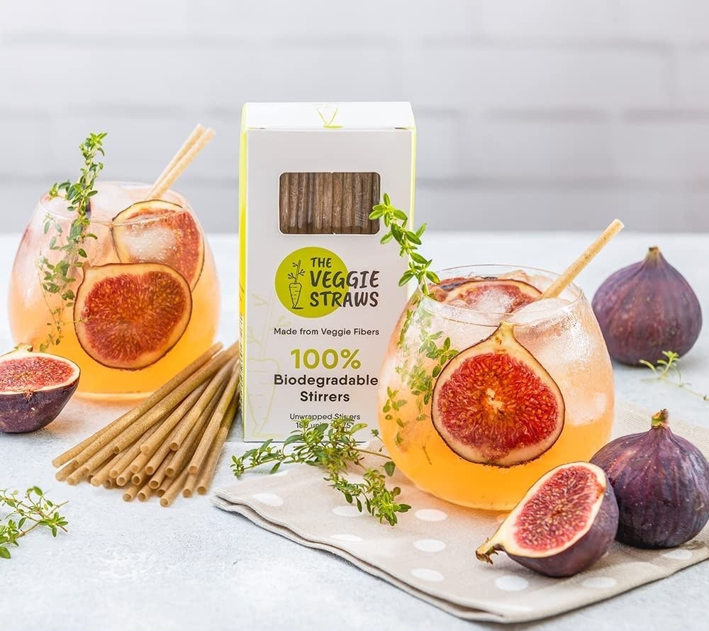 The box of straws next to mixed drinks with caption reading "eco-friendly stirrer straws produced from non-toxic materials that are safe for both you and the environment"