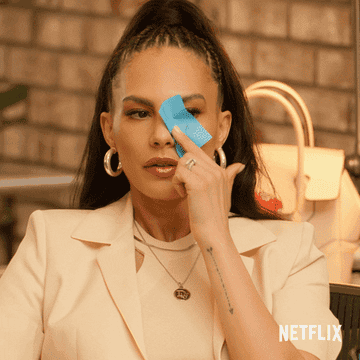 a gif of a woman blotting her face