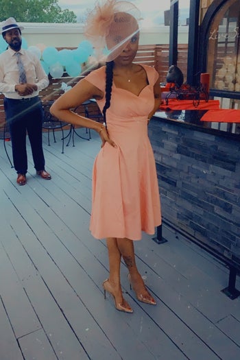 a reviewer wearing the dress in peach
