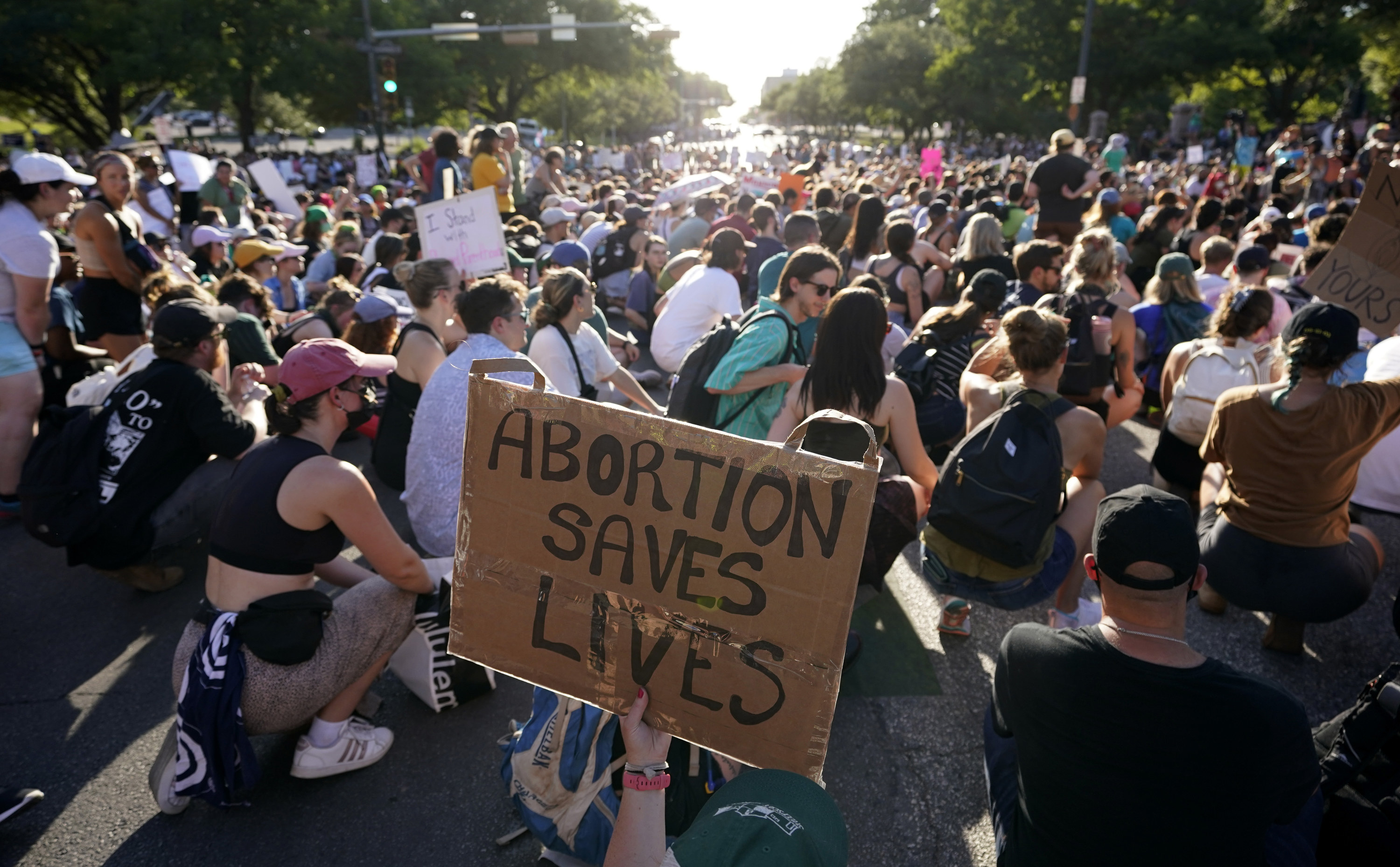 A large crowd, some with signs, including &quot;Abortion saves lives&quot;