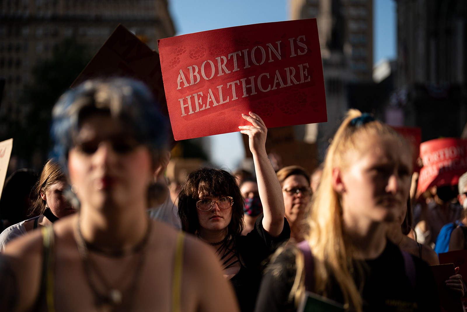 Person in a crowd of protesters holds up sign &quot;Abortion is healthcare&quot;
