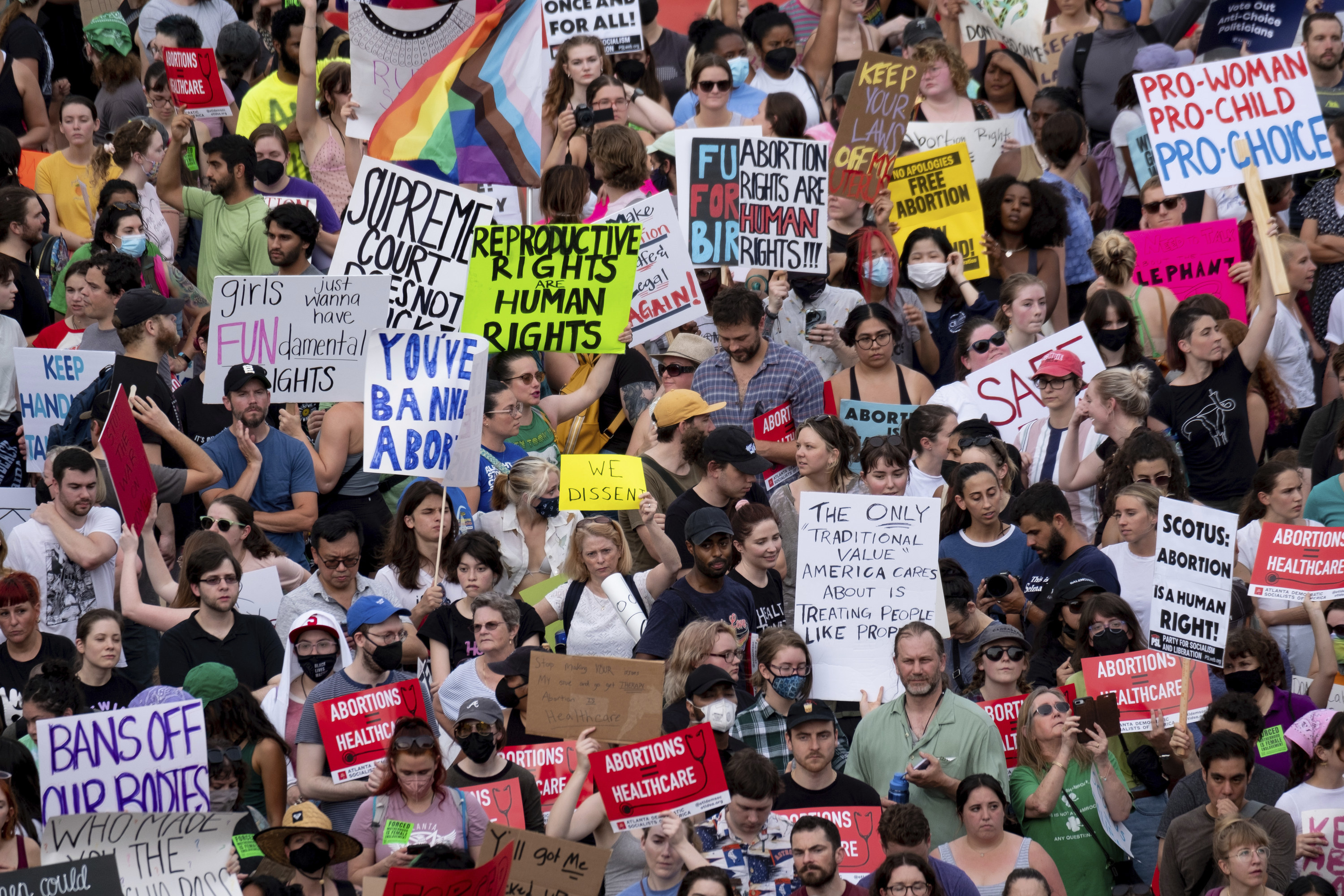 A large crowd holding up signs such as &quot;Bans off our bodies&quot; and &quot;Reproductive rights are human rights&quot;