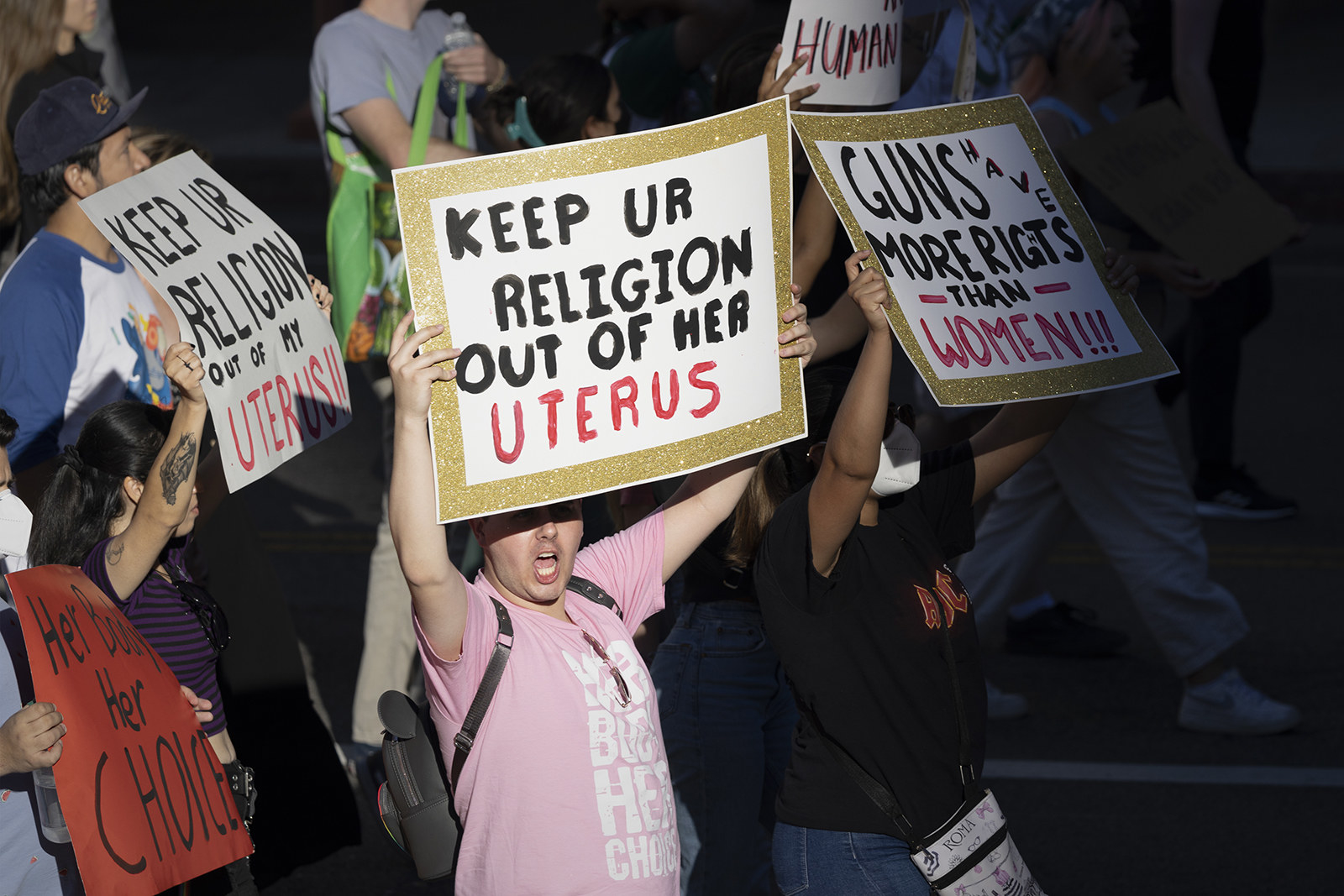 People march and hold up signs, including &quot;Keep ur religion out of her uterus&quot;