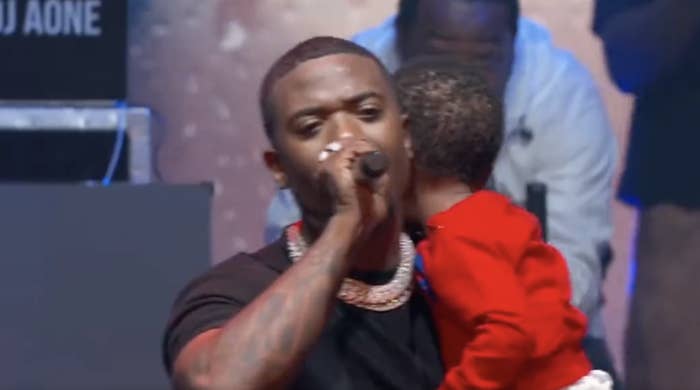 close up of Ray J performing while holding his kid