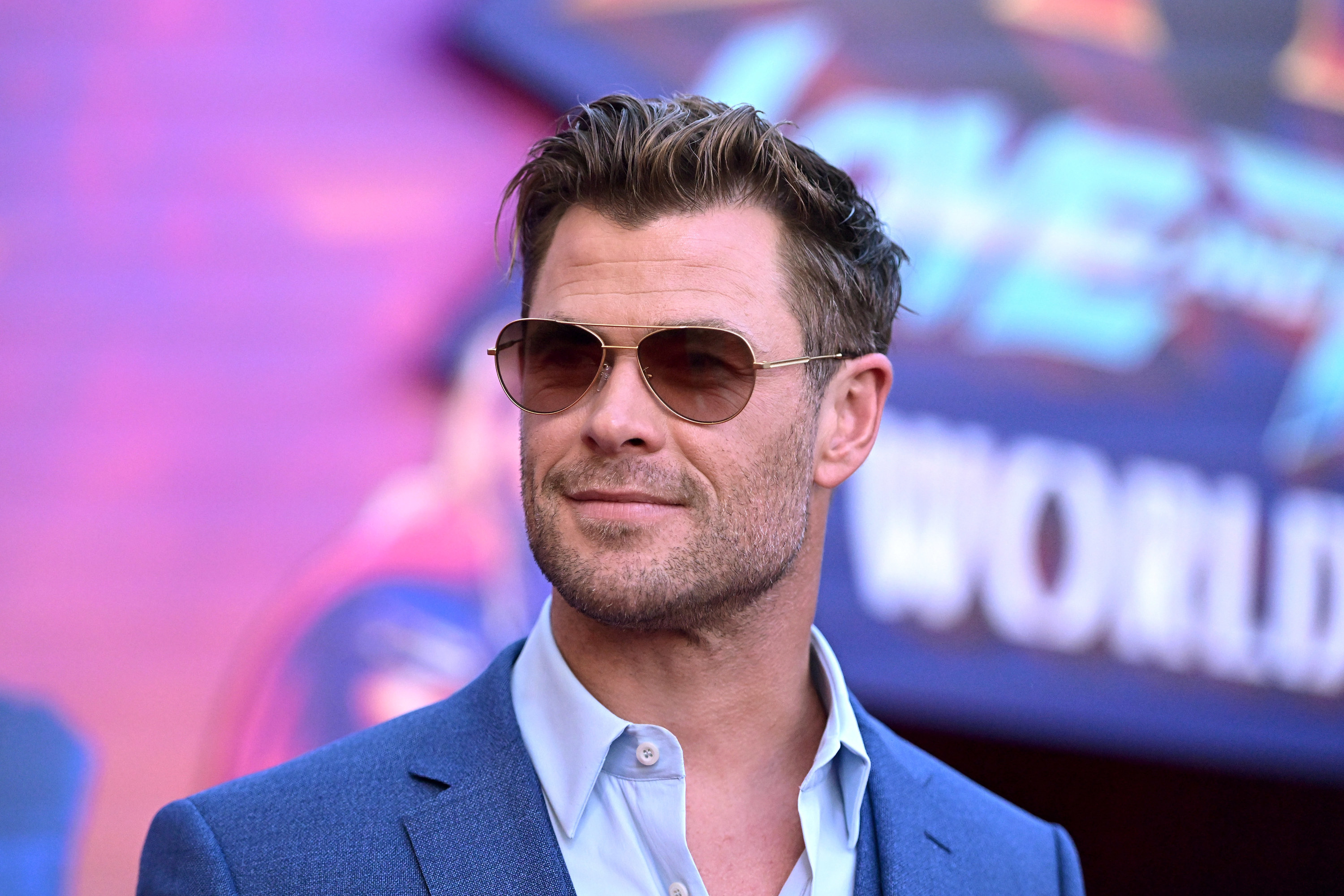 close up of chris wearing sunglasses and a suit