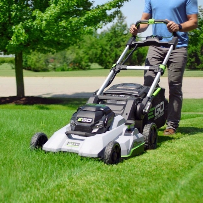 a person pushing a cordless, electric mower on a lawn