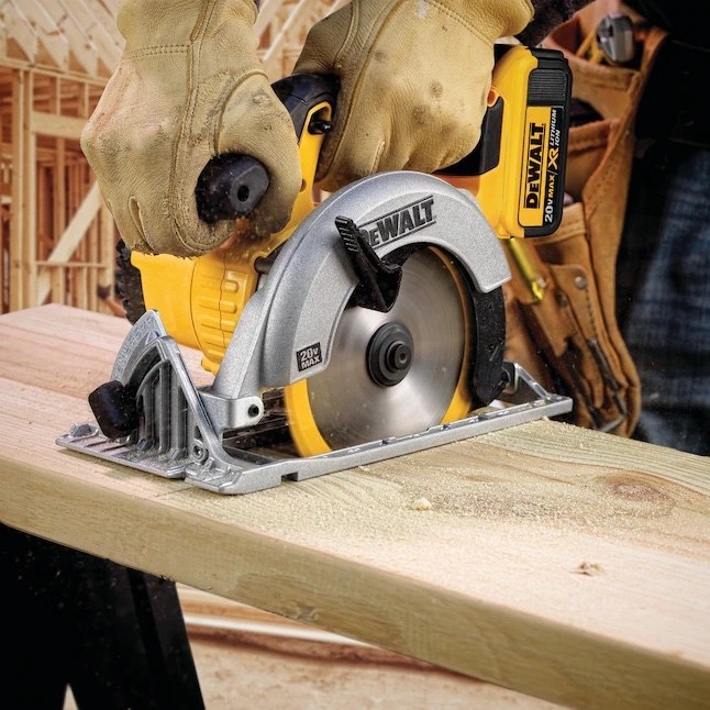 a person using a yellow and black cordless circular saw to cut wood