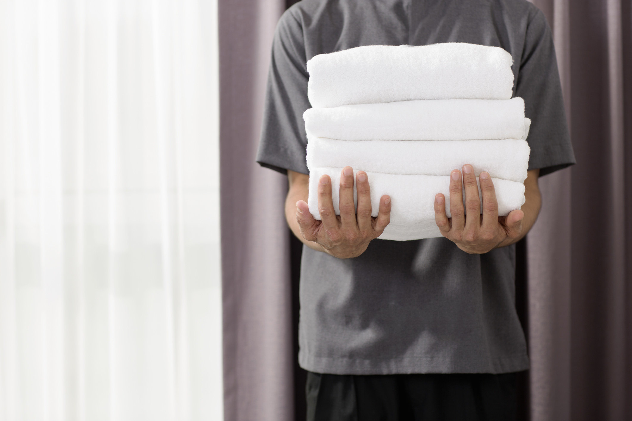 A person holding a stack of towels