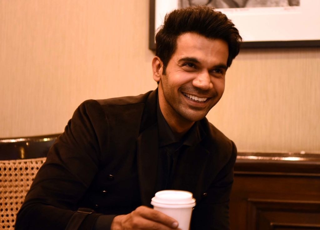 Rajkummar Rao smiles while holding a cup of coffee