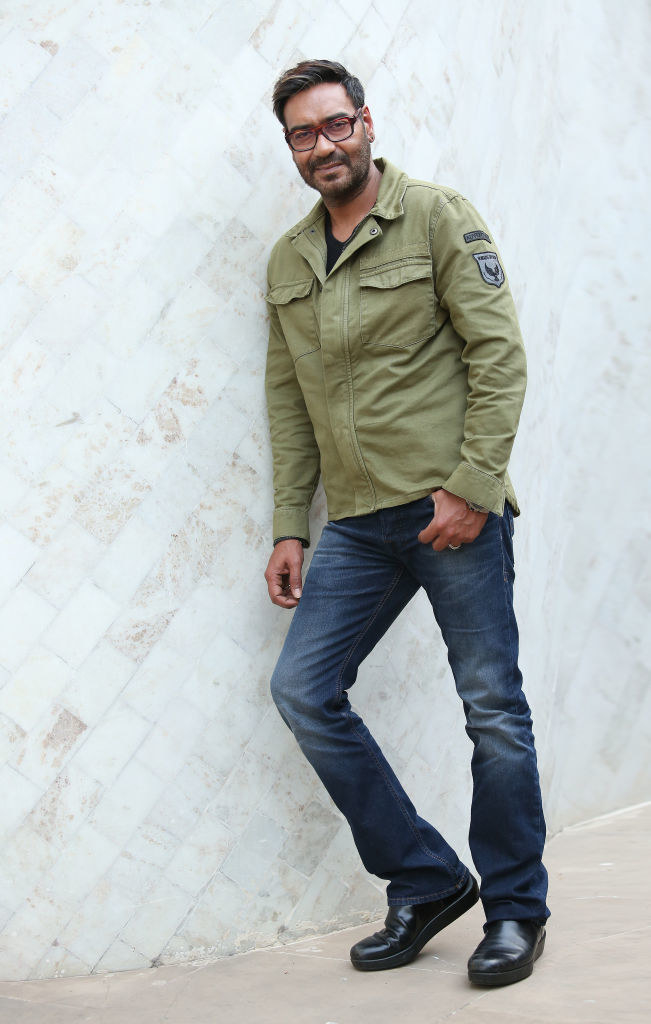 A bespectacled Ajay Devgn poses for a picture with one of his hands in his pockets