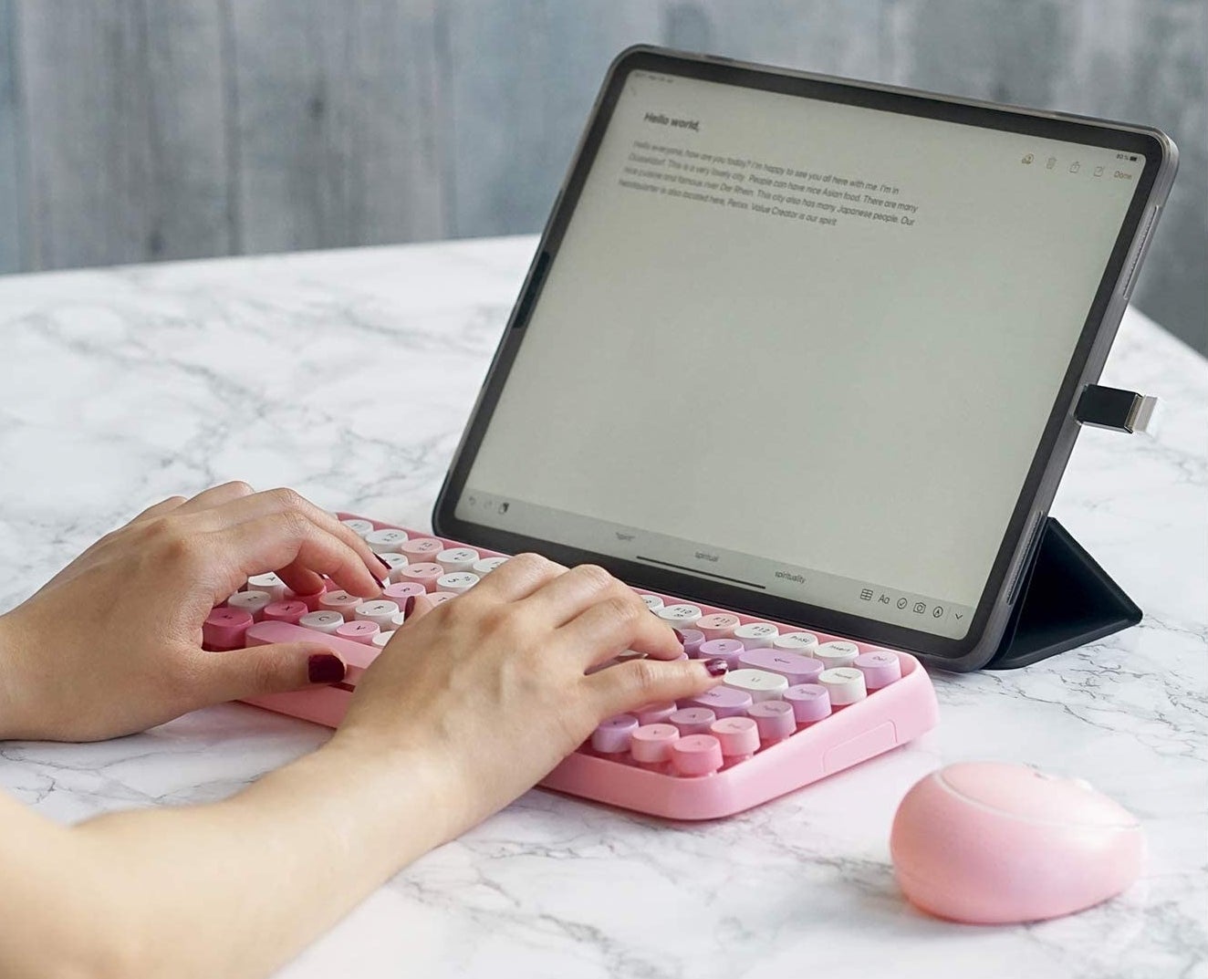 person typing on the keyboard with a tablet