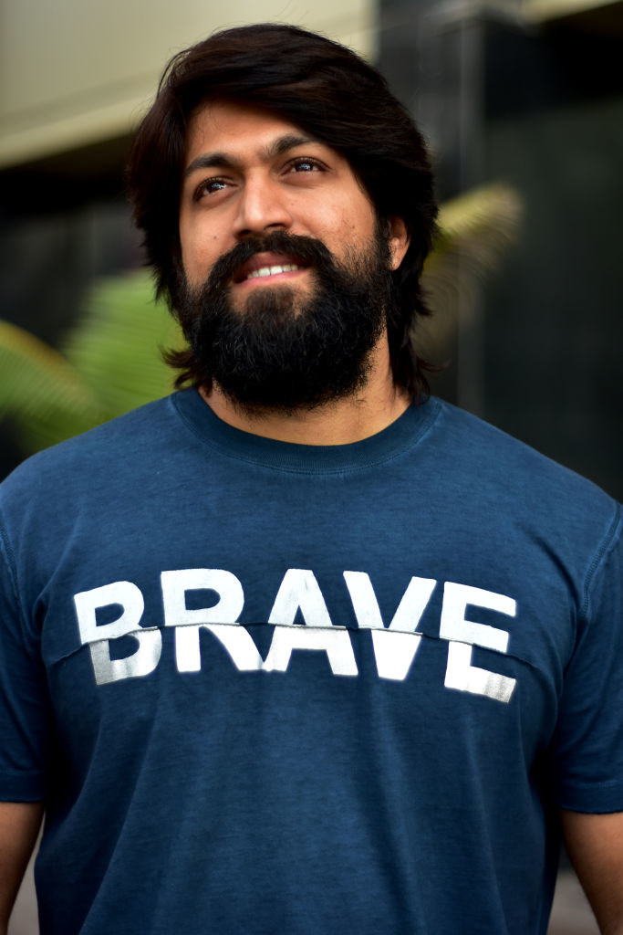 Yash smiles and poses for a picture while wearing a T-shirt that says, &quot;brave&quot;