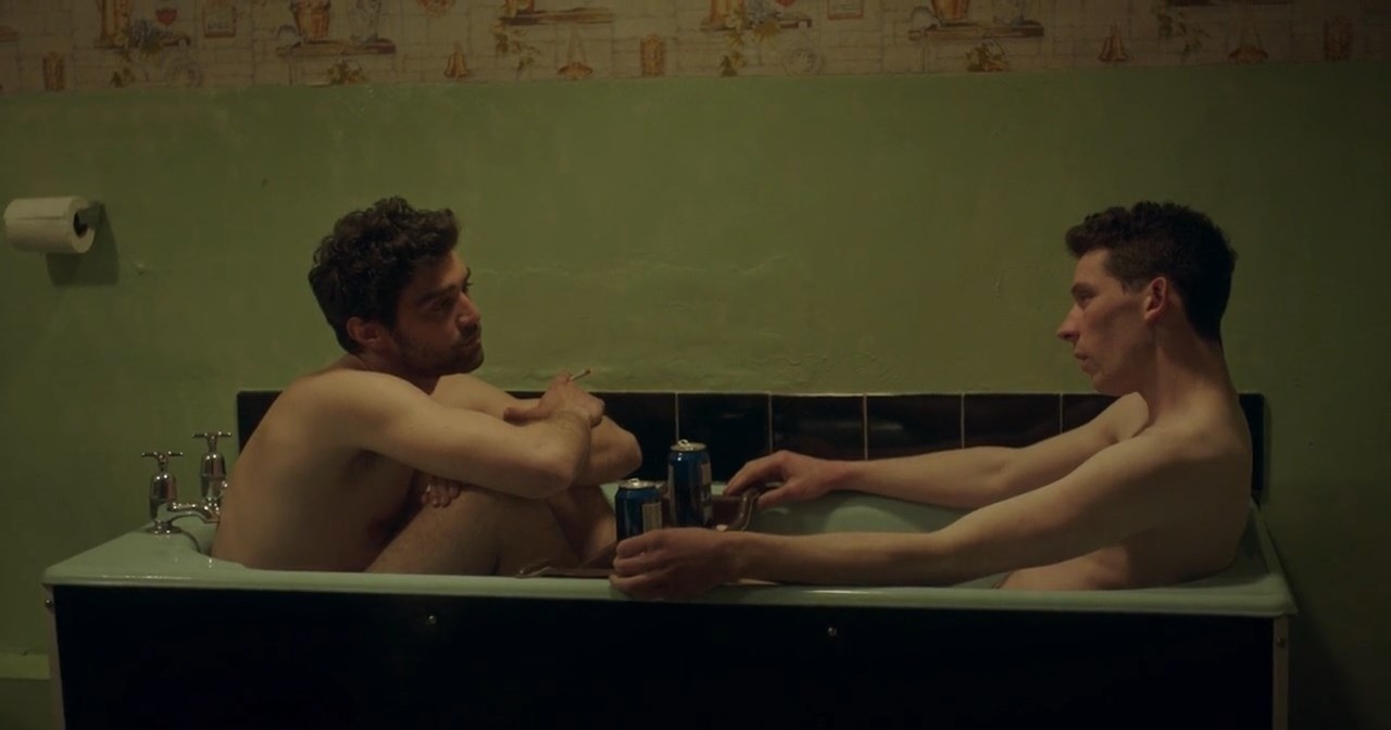 Two men sit in a bathtub