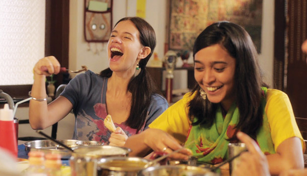 Laila (Kalki Koechlin) and Khanum (Sayani Gupta) sitting at a dining table and laughing while eating