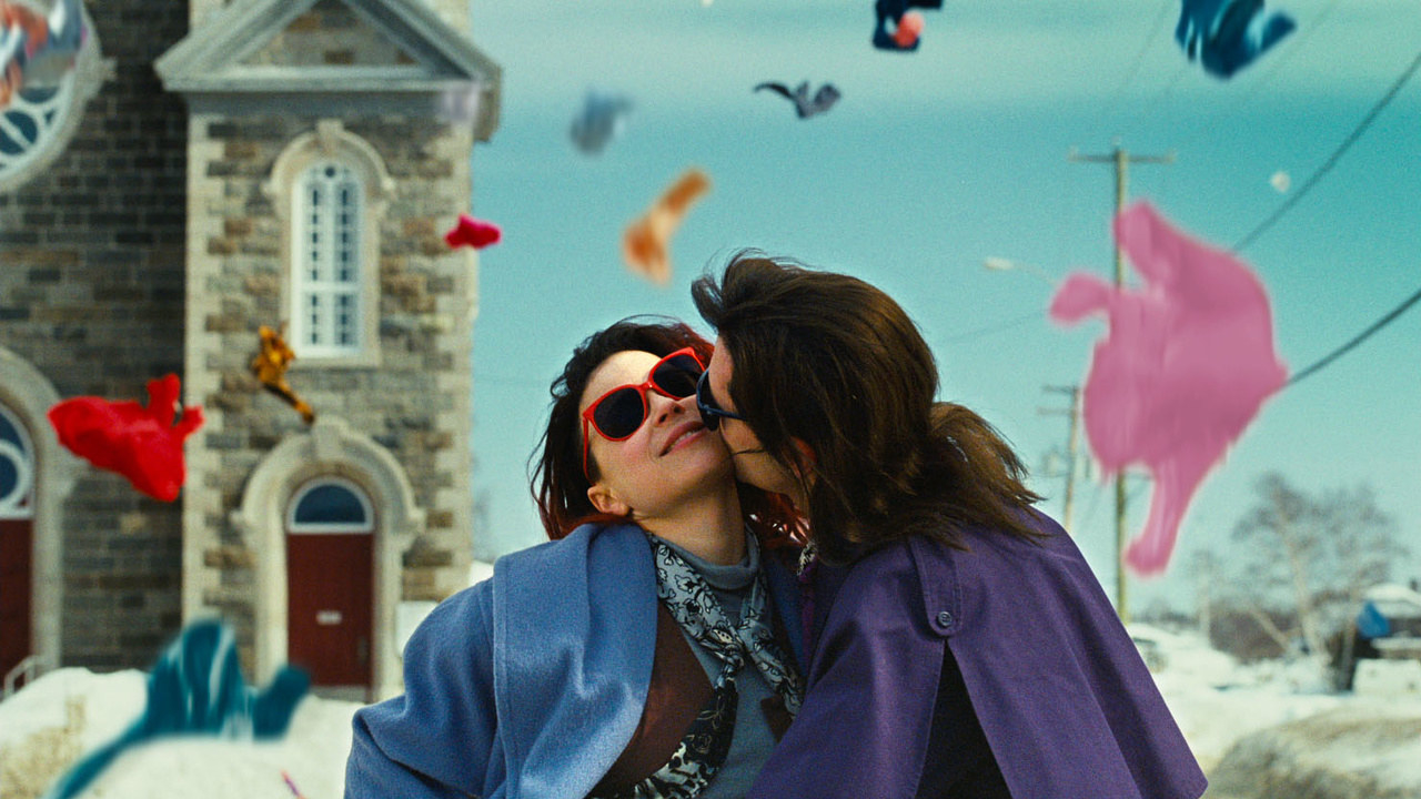Laurence (Melvil Poupaud) planting a kiss on Fred&#x27;s (Suzanne Clément) left cheek with confetti flying in the air