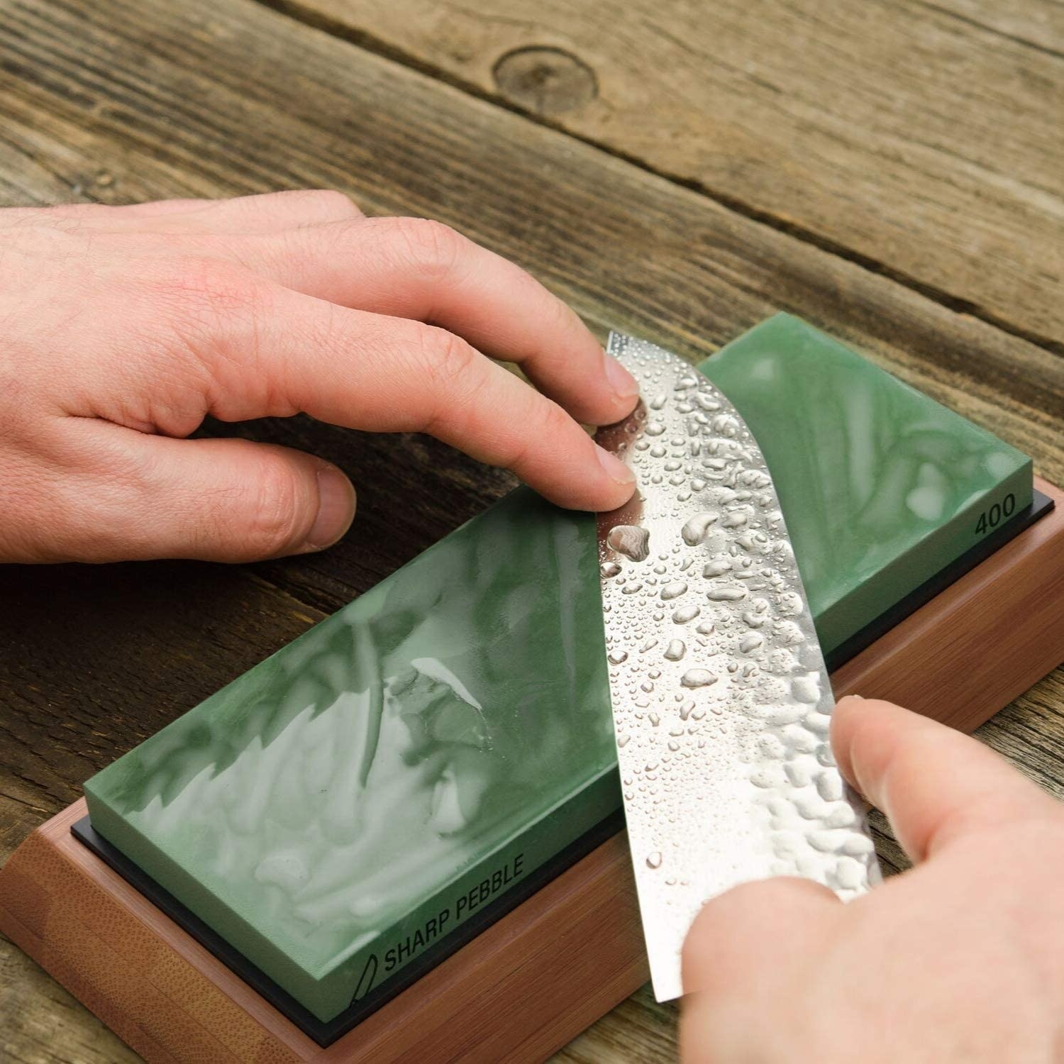 a person sharpening a knife on the wetstone