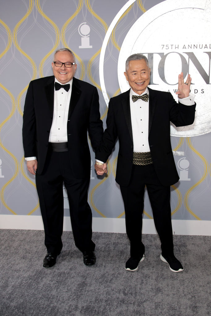 George and Brad Takei holding hands and wearing tuxes