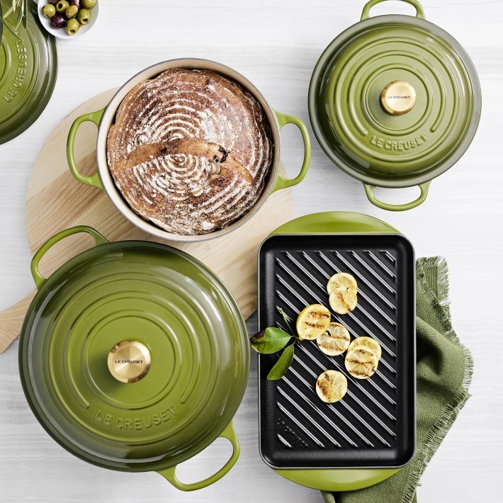 An assortment of olive green baking and cooking cast iron cookware are shown