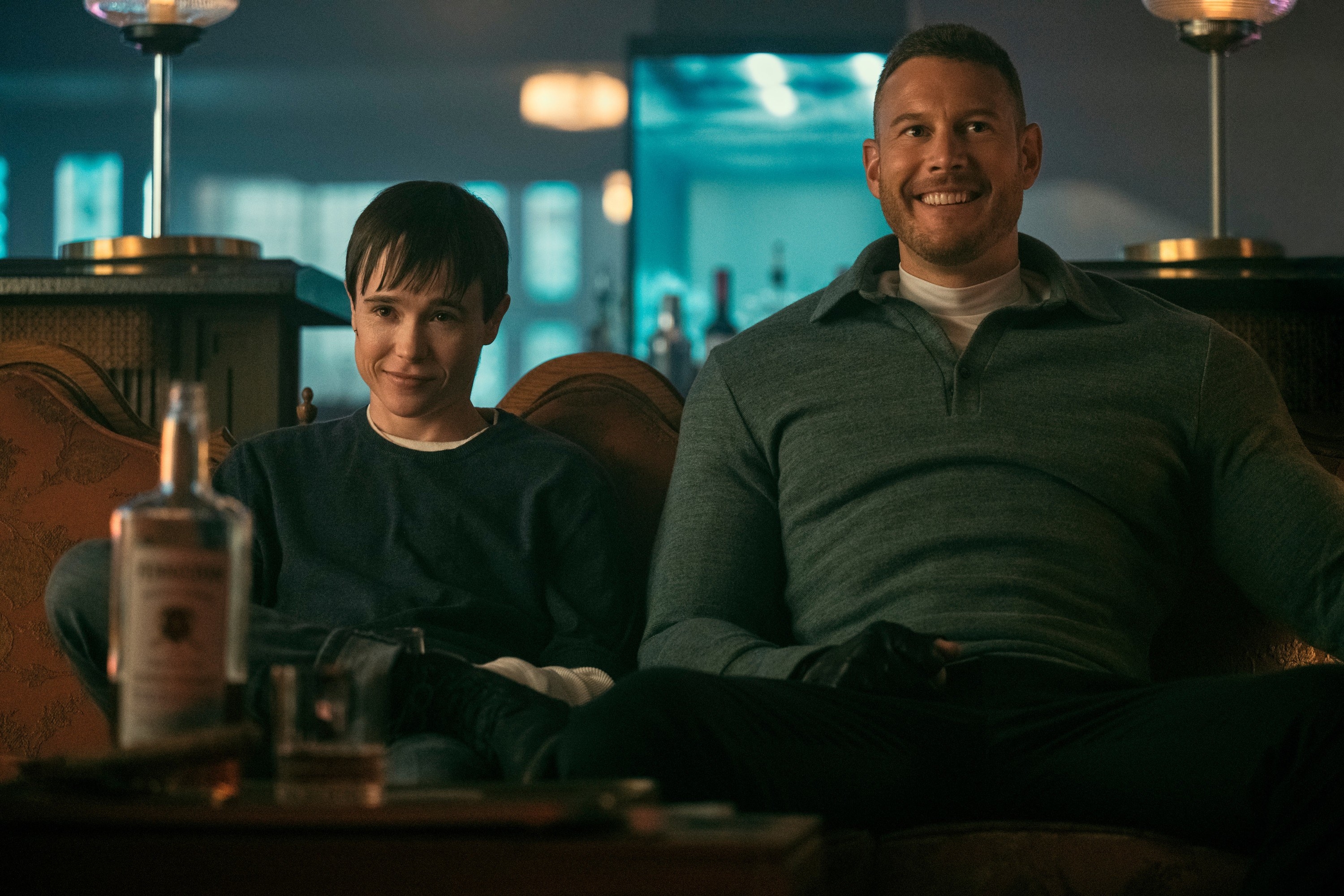 Viktor sits next to Luther on a couch