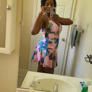 reviewer in pink swimdress with blue and green tropical leaf print