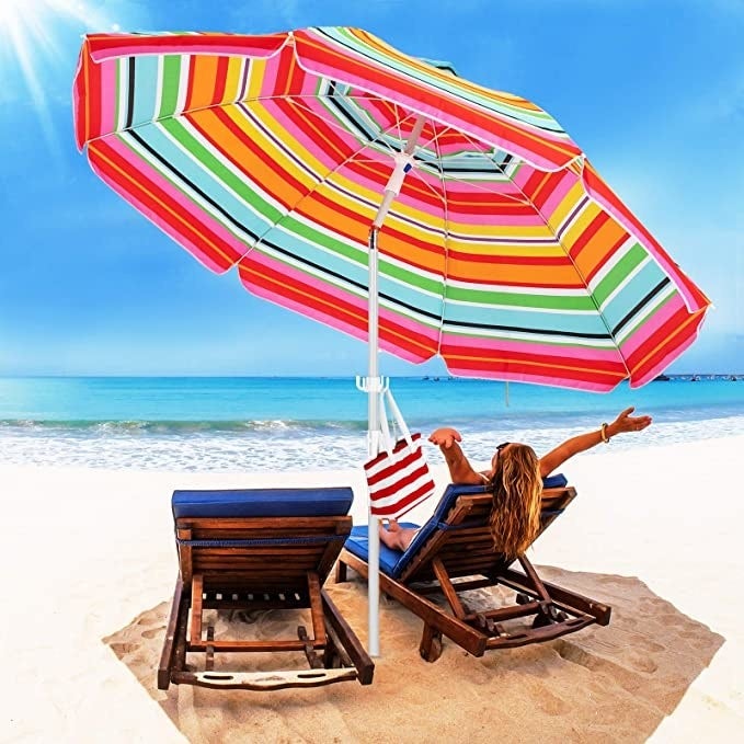 A person sitting under an umbrella at a beach