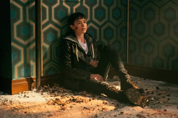 Viktor sits on the ground amid rubble