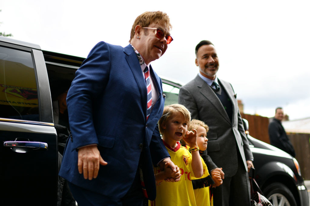 Elton John and David Furnish stepping out of a limo with their sons