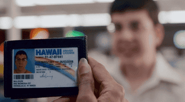 An underage boy showing a fake ID.